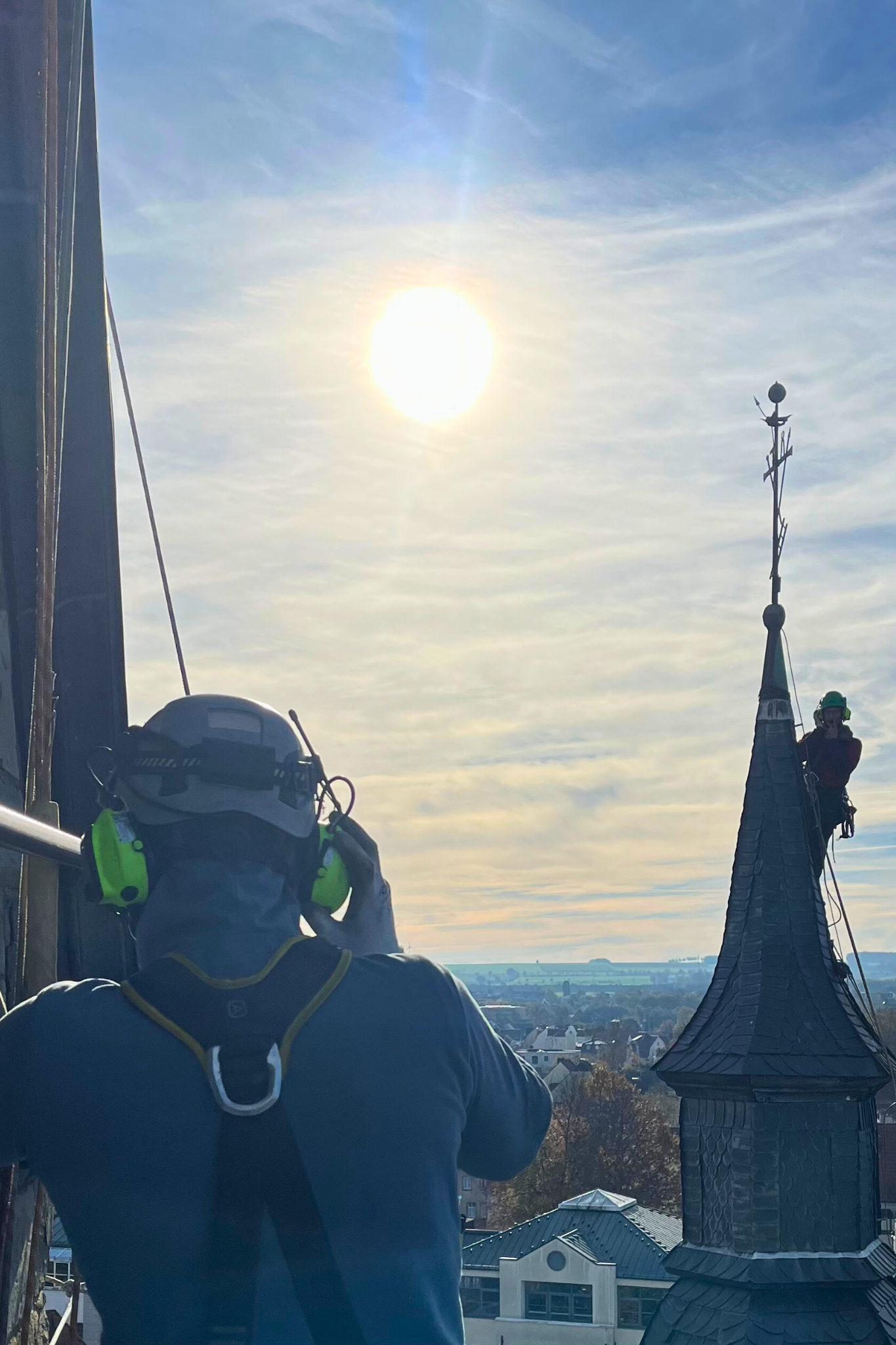 Industriekletterer bei Schieferarbeiten an einer historischen Kirchturmspitze mittels Seilzugangstechnik