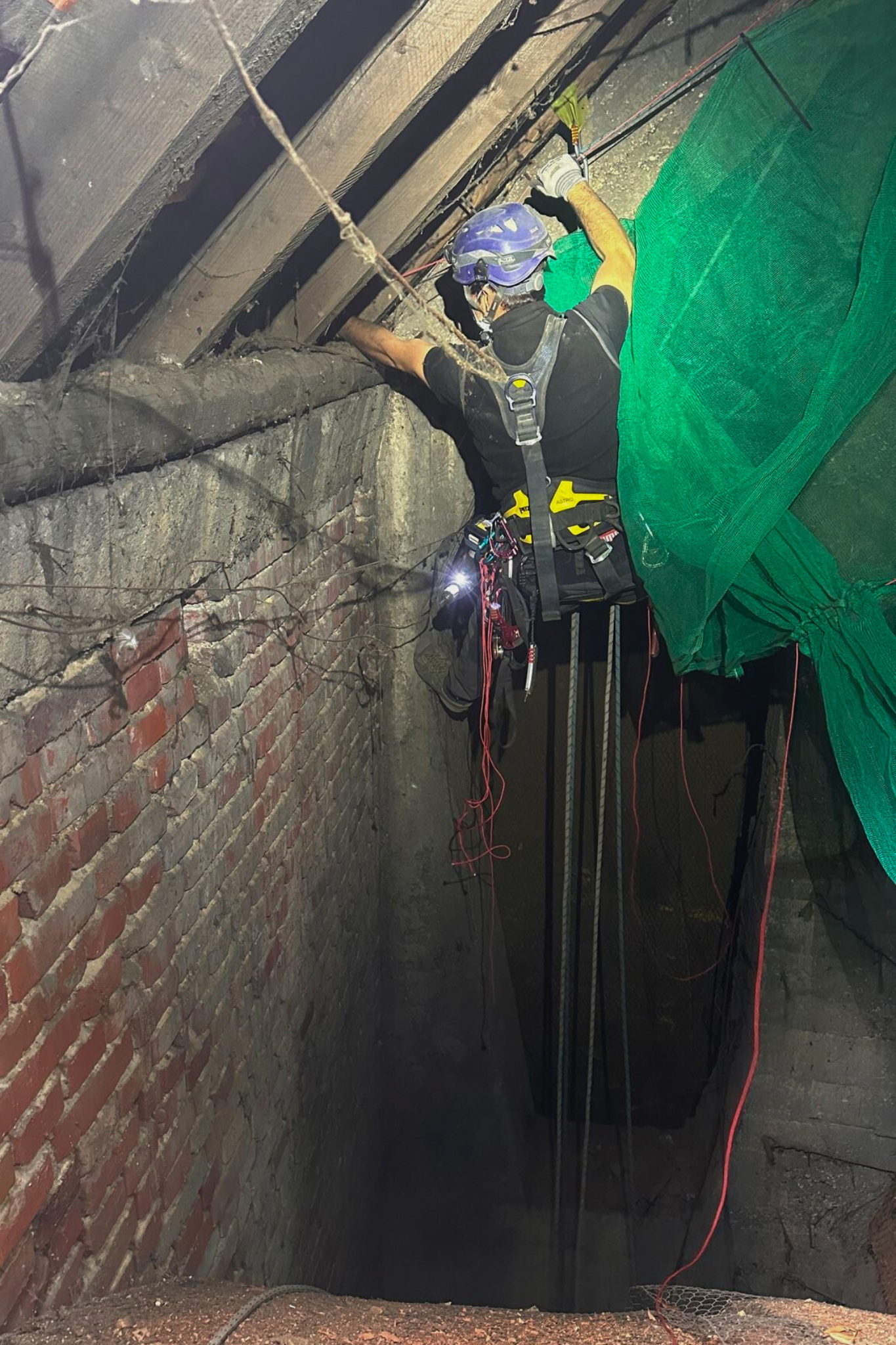 Industriekletterer bei Installation eines Schutznetzes im schwer zugänglichen Dachbereich